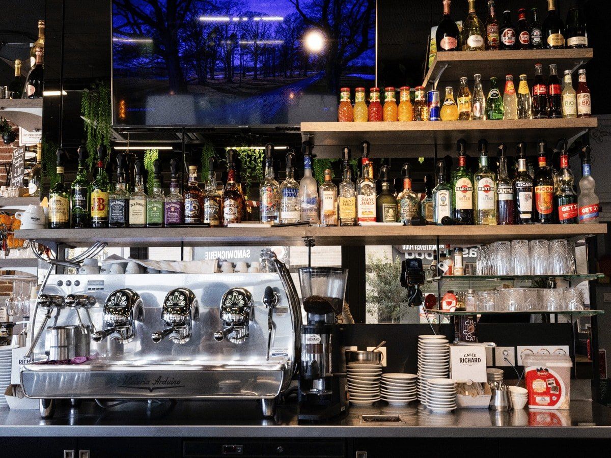 Le comptoir du bar, machine à café et étagères de bouteilles